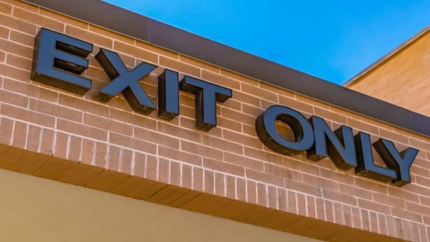 istock Panorama frame Exit only sign on the exterior brick wall of a building with shiny window 1154845073