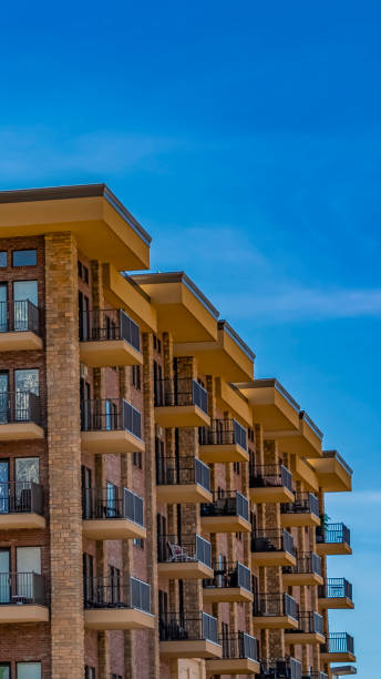 istock Panorama Residential brick building with balconies against blue sky with thin clouds 1154850394