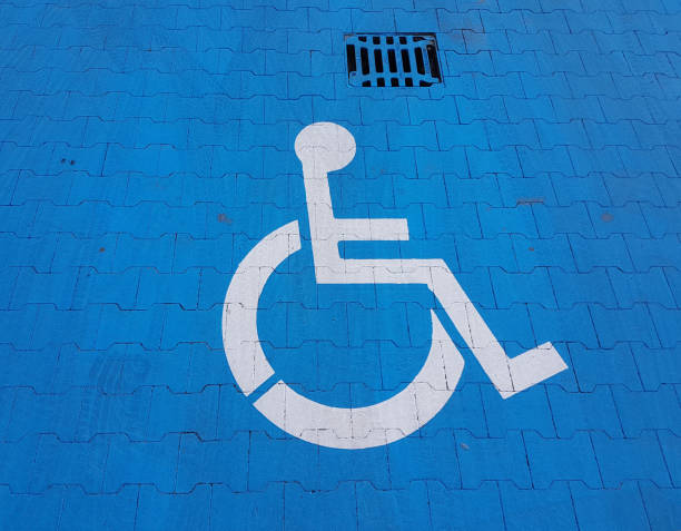 istock Road marking sign on a blue background denoting parking for a disabled vehicle. The convenience of parking a vehicle. The journey of people with disabilities in a wheelchair. Free space for the needy 1154850563
