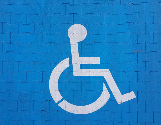 istock Road marking sign on a blue background denoting parking for a disabled vehicle. The convenience of parking a vehicle. The journey of people with disabilities in a wheelchair. Free space for the needy 1154850566