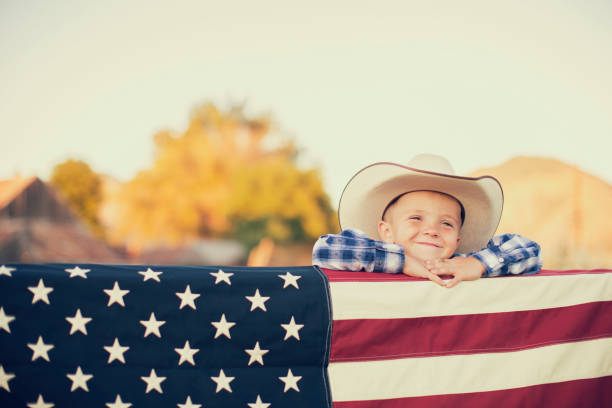 istock Young Cowboy with American Flag 1154852937