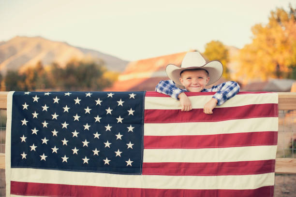 młody kowboj z amerykańską flagą - cowboy cowboy hat hat summer zdjęcia i obrazy z banku zdjęć