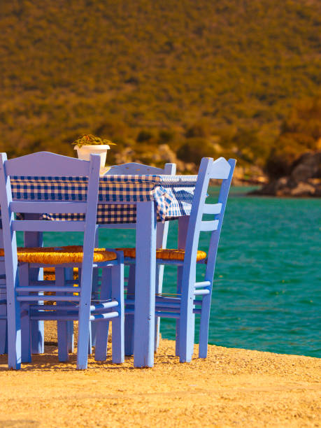 istock Open cafe outdoor restaurant in Greece on sea shore 1154854187