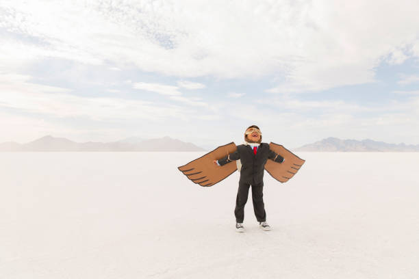 istock Young Business Boy with Cardboard Wings 1154854357