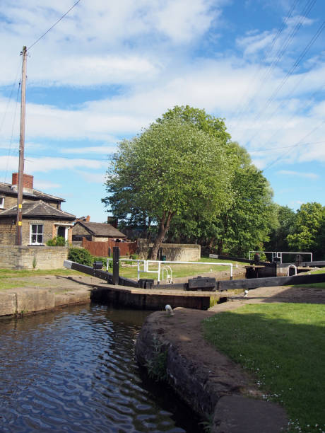 the exit lock gates at brighouse basin on the calder and hebble navigation canal with 19th century lock keepers building