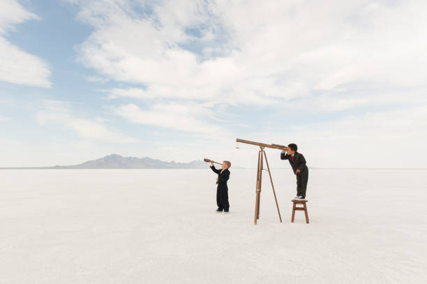 istock Young Businessmen with Telescopes 1154855331