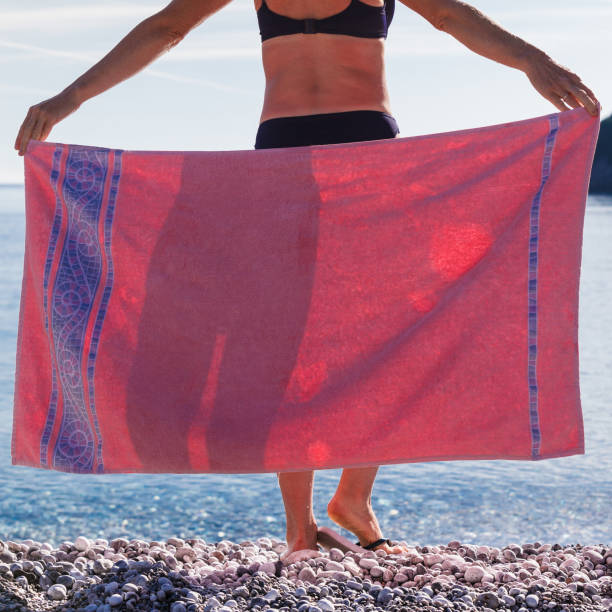 istock Woman on beach covering hips with towel 1154856286