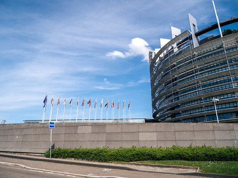 Strasbourg, France - May 26, 2019: European Parliament headquarter with all European Union flags waving - clear blue sky in background