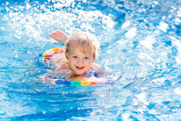 istock Child learning to swim. Kids in swimming pool. 1154859433