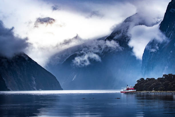 tourist boat cruising in milford sound fjordland national park tourist boat cruising in milford sound fjordland national park milford sound stock pictures, royalty-free photos & images