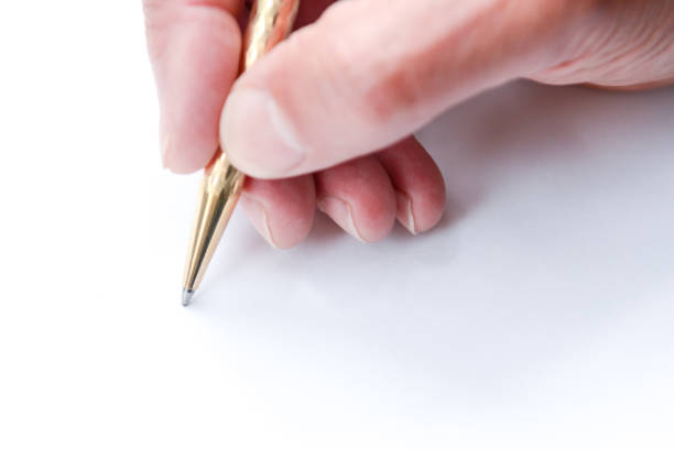 istock Man writing with pen on paper, close up of hand hollding pen to write on paper document 1154863243