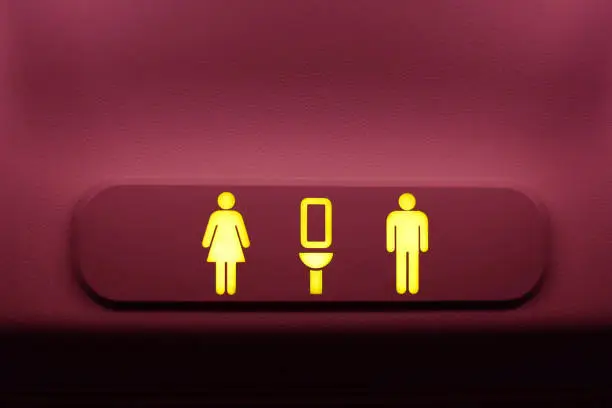 Photo of pink toilet sign on airplane