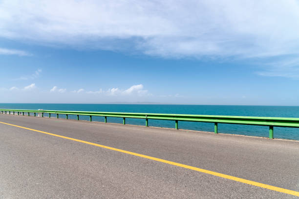 The lakeshore highway is against a blue sky and white clouds