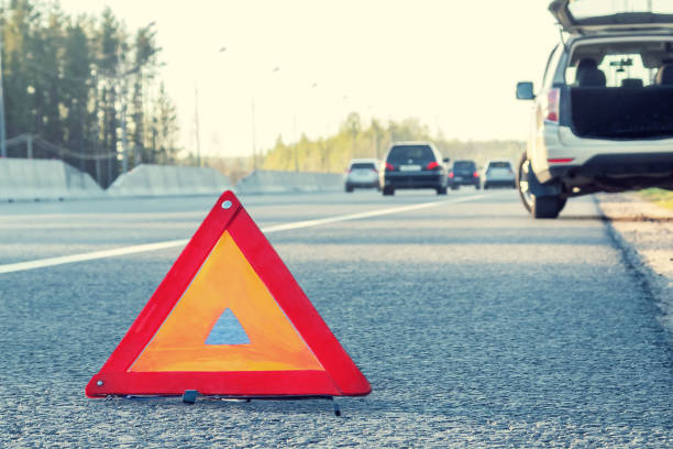 broken car on the side of the highway and an emergency stop sign - avaria no carro imagens e fotografias de stock