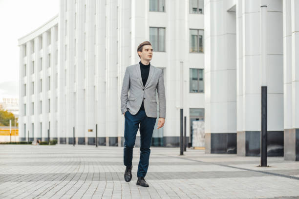 istock Distant plan of young business man going next to modern business center. 1154868919