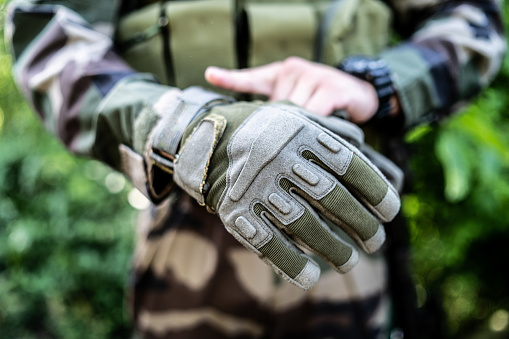 Special police military soldier putting battle gloves on for the mission action combat intervention