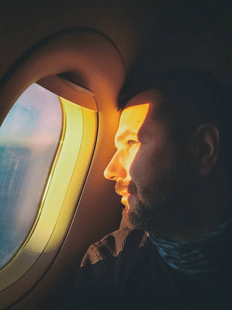 istock Man in the aircraft look into the window 1154872608