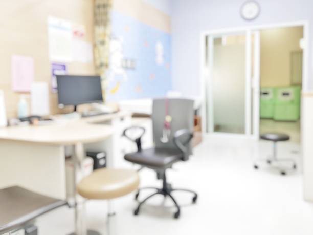 Blur abstract background inside empty patient examination room with bed in OPD ward. Blurry doctor desk for diagnosis sick people working space in hospital. Defocused interiors healthcare work place