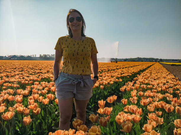 istock Woman between the orange flower fields in the Netherlands 1154872773