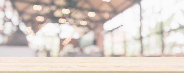 istock Empty wooden table top with cafe restaurant or coffee shop window interior abstract blur defocused with bokeh light background for montage product display 1154872899