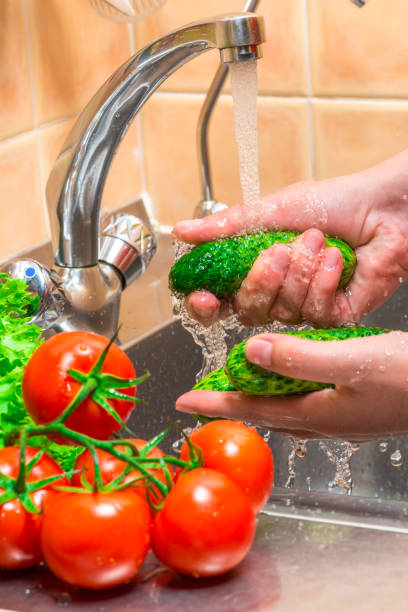 istock women's hands washing vegetables in the kitchen under running water 1154872912