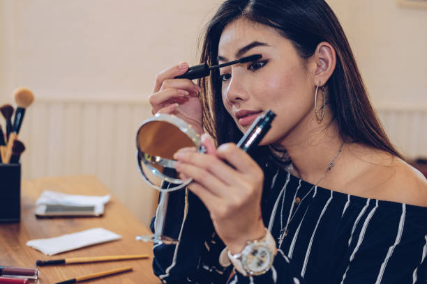 istock asian woman applying makeup cosmetic 1154873184