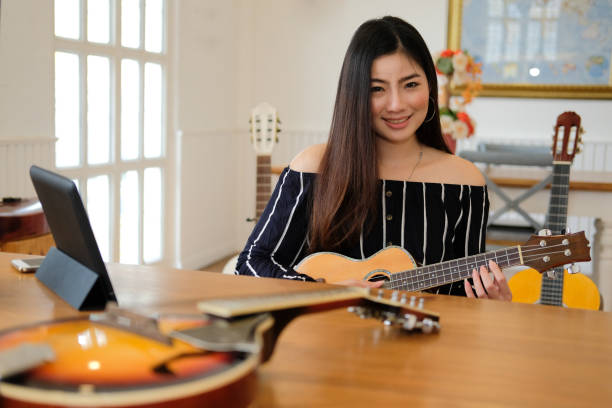 istock woman playing guitar. leisure lifestyle concept 1154873202