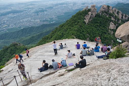 Seoul, Korea - June 8th, 2019: Hikers taking a break on Baekundae, top of Bukhansan Mountain in Seoul Korea. 북한산 백운대