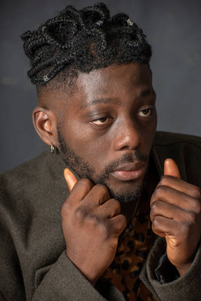 istock West African man pulls his coat collar up against the cold. 1154874788