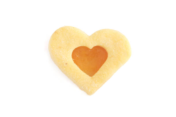 A strawberry jam shaped heart on a shortbread biscuit - white background