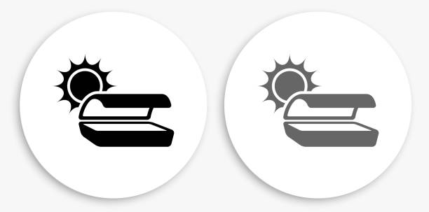 Tanning Bed Black and White Round Icon Tanning Bed Black and White Round Icon. This 100% royalty free vector illustration is featuring a round button with a drop shadow and the main icon is depicted in black and in grey for a roll-over effect. tanning bed stock illustrations