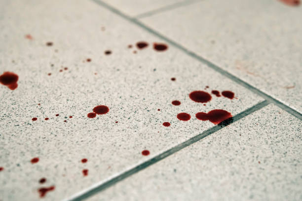 Conceptual image with blood on it resting on tiles on floor Conceptual image with blood on it resting on tiles on the floor ketchup-splash stock pictures, royalty-free photos & images
