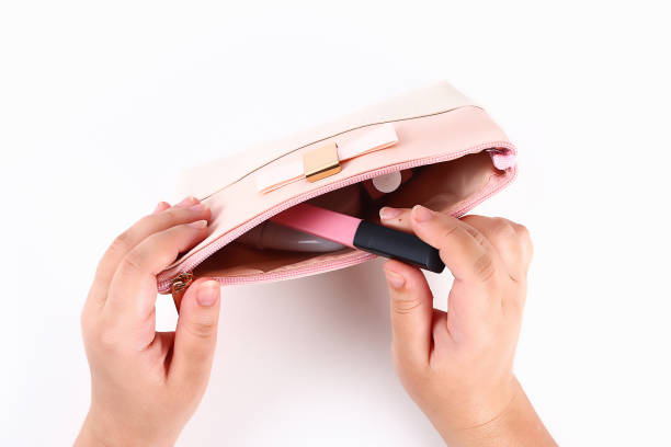 istock The girl pulls out cosmetics from a cosmetics bag on white background. Top view. 1154897124