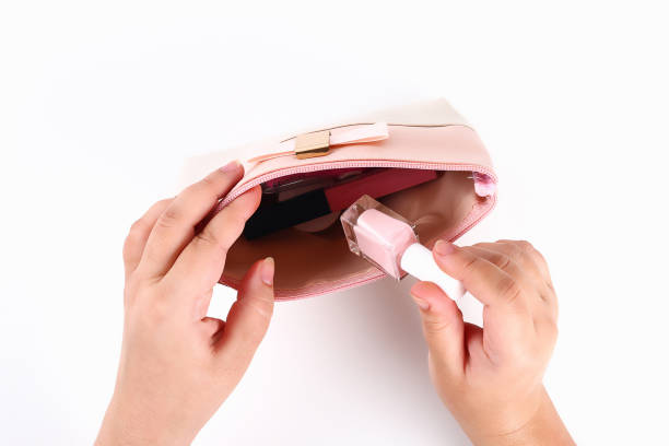istock The girl pulls out cosmetics from a cosmetics bag on white background. Top view. 1154897139