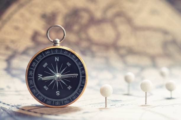 istock Compass on old vintage brown map background, journey planning concept, copy space 1154897299