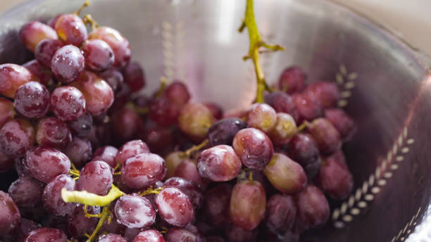istock Washing red seedless grapes in stainless steel colander. 1154901109