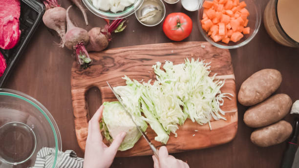 istock Shredding green cabbage for beet soup, borscht. 1154901302