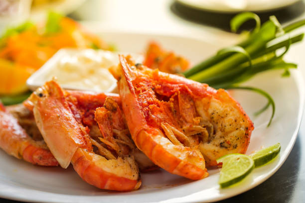 istock Beautiful orange shrimp cut in half on a plate on the table 1154901563