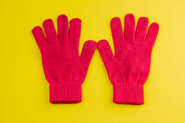 two red gloves isolated on a vibrant yellow background