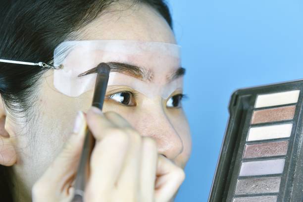istock Eyebrows shaping makeup template, Asian women filling eyebrows to look thicker, Learning doing self makeup. 1154908148