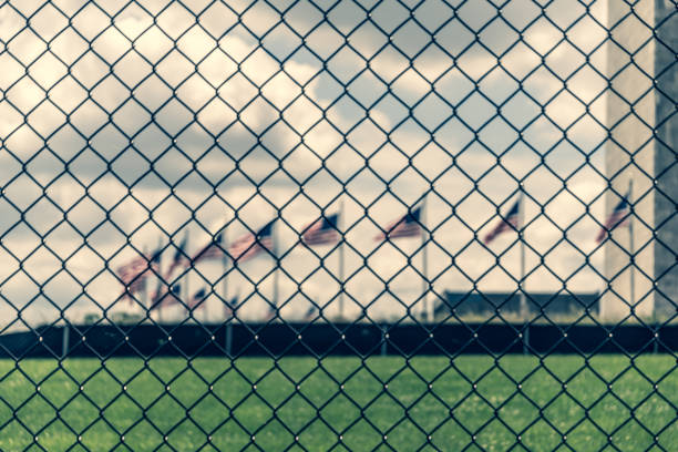 istock View through chain linked fence towards flags surrounding the Washington Monument 1154912428