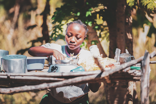 Africa, Village Life, Routines - A Young African Woman preparing the meal on the drying rack
