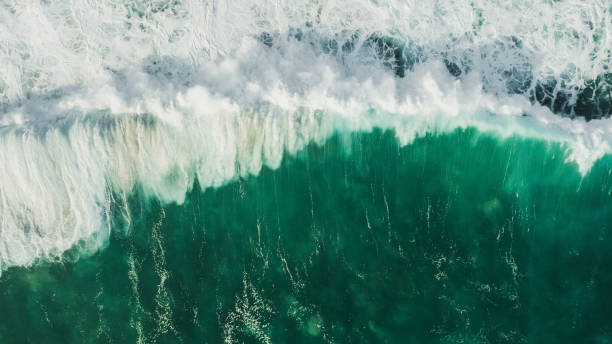 istock Aerial wave background. Drone shot directly from above, green turquoise color, huge waves. Empty space 1154916221
