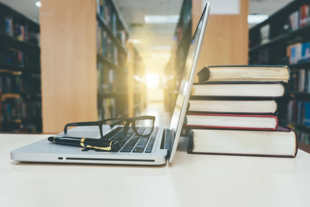 istock Laptop computer shown the old books 1154916364