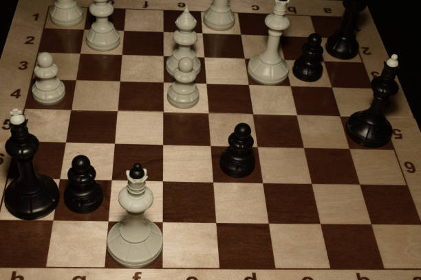 istock Wooden chess board and black pawns as a game theme 1154916562