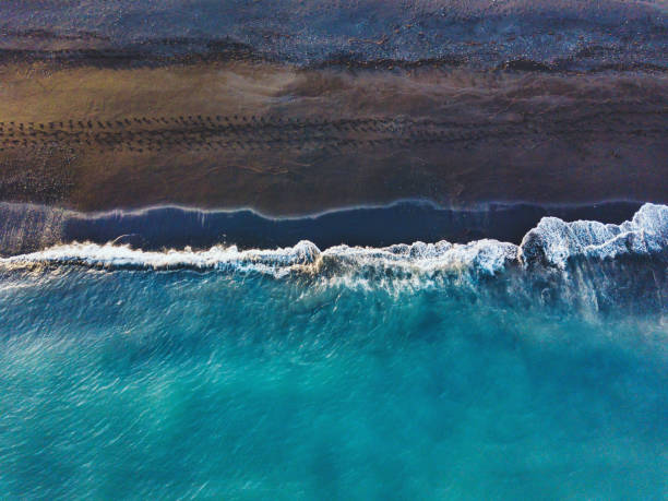 blue ocean wave on black sand beach in Iceland