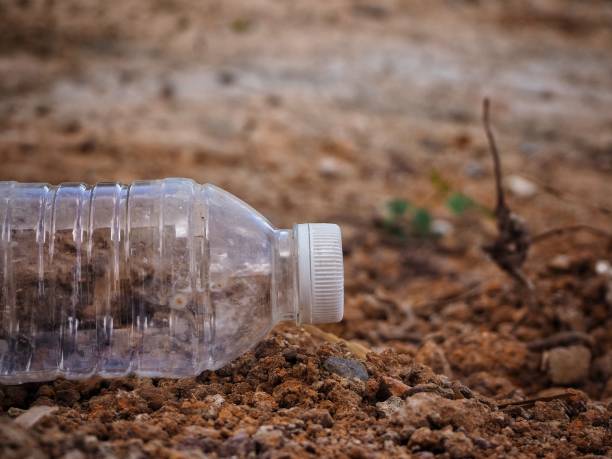 istock used bottle plastic on brown ground. environmental pollution. long life garbage and recycle plastic concept - image 1154919410