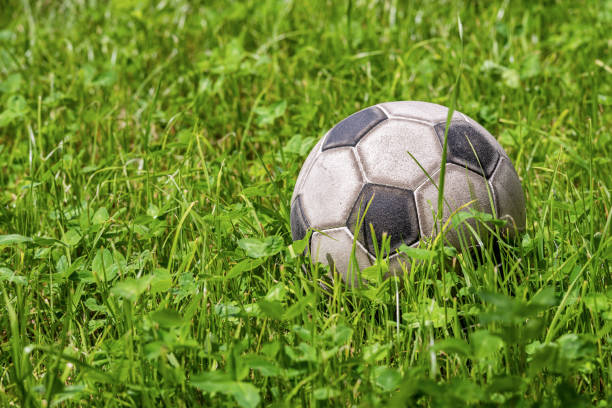 緑の草の上に革のサッカーボール-サッカースポーツ - soccer field dirty soccer outdoors ストックフォトと画像