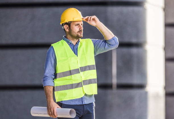 istock Young male architect with blueprints on the street. 1154924117