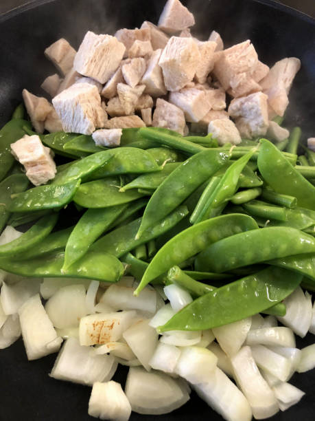 image de la recette de curry vert thaï ingrédients d’oignons coupés en dés, mange-tout et haricots verts français, cubes de poitrine de poulet congelés, lait de coco et pâte de curry de poulet thaï, sauté de légumes asiatiques non-veg avec pime - tout photos et images de collection